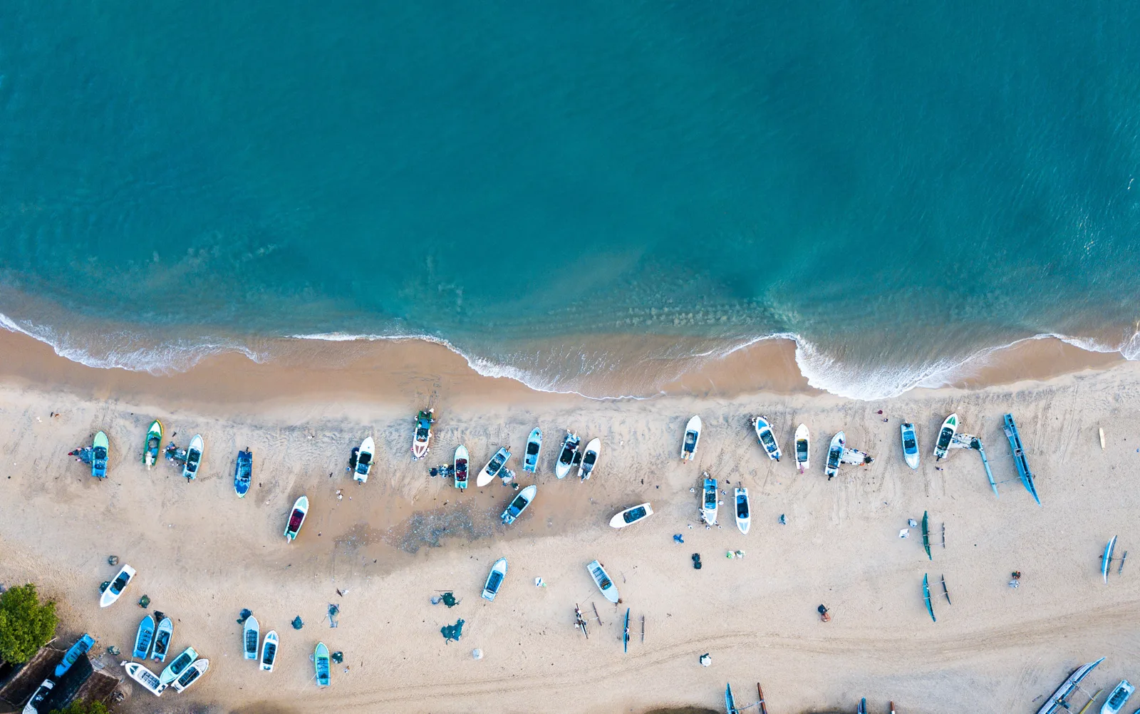 Aerial view of waves, beach and fishing boats at Arugam Bay