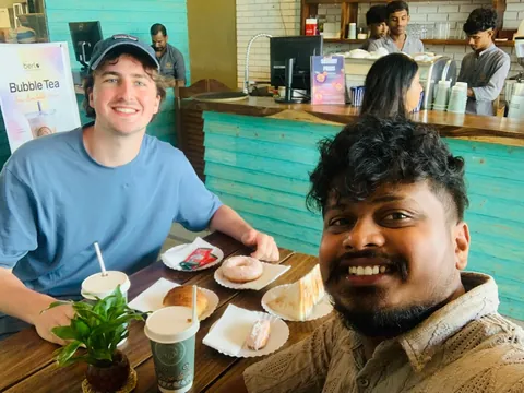 A driver and a traveller at a table with food and drinks